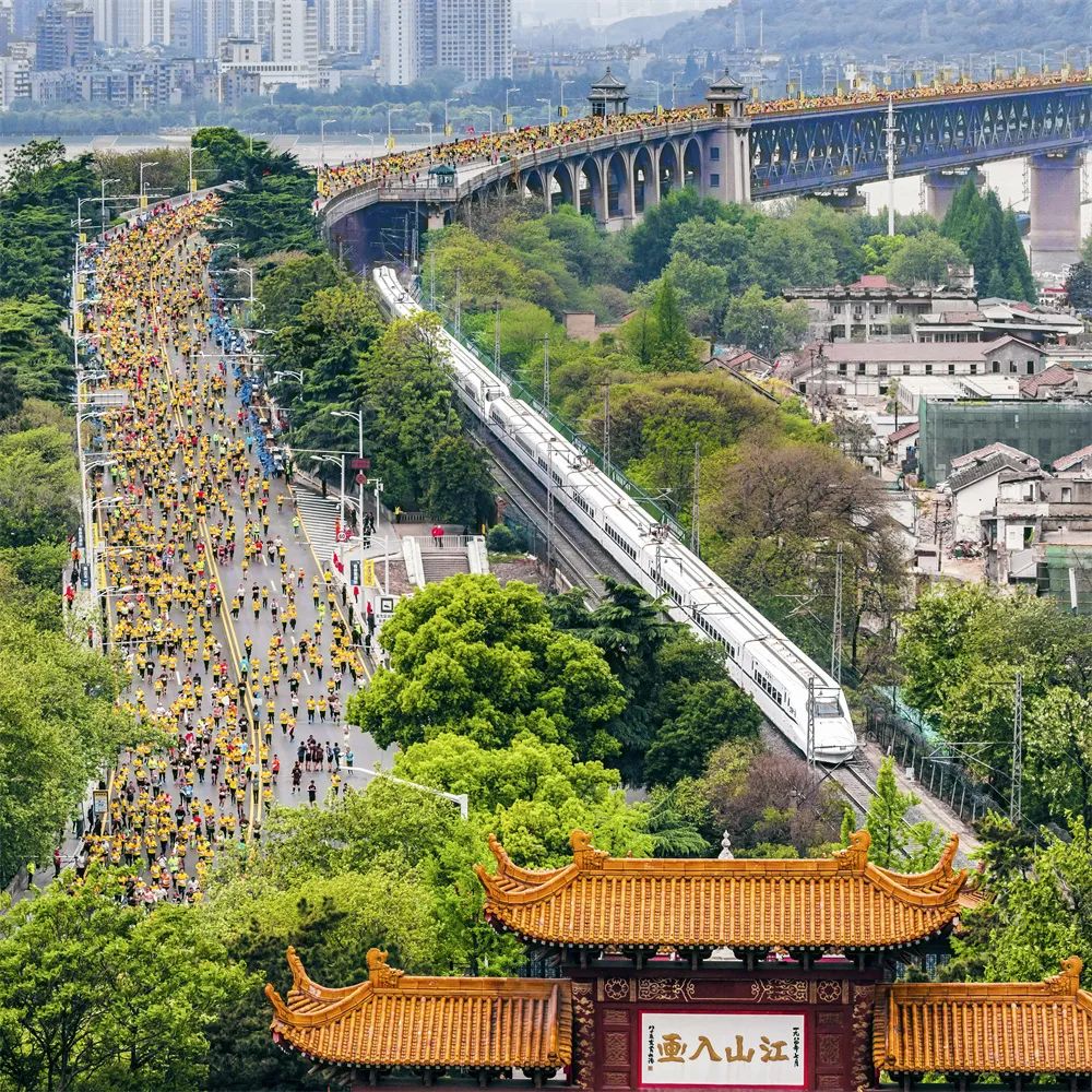 齊頭并進 姜濤 攝2019年4月14日，參加馬拉松比賽的選手們經(jīng)過武漢長江大橋，與動車同行，與黃鶴樓同框。.jpg